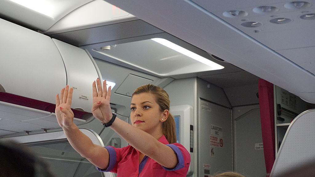 Flight attendant shows emergency procedures