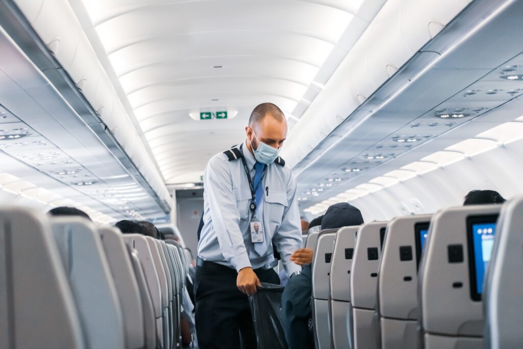 Flight attendant collecting trash